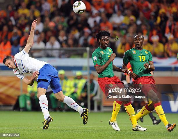 Robin van Persie of Netherlands and Nicolas Nkoulou and Stephane Mbia of Cameroon during the 2010 FIFA World Cup South Africa Group E match between...