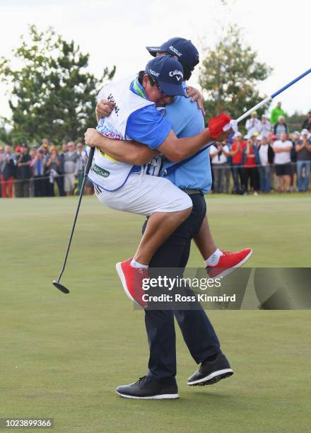 Andrea Pavan of Italy celebrates victory with his caddie on the 18th green during day four and final round of the the D+D REAL Czech Masters at...