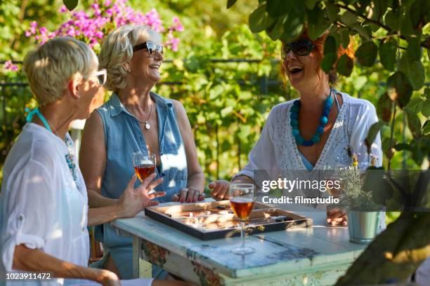 senior vrouw spelen backgammon - backgammon stockfoto's en -beelden