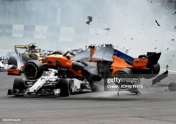 McLaren's Spanish driver Fernando Alonso crashes ontop of Sauber F1's Monegasque driver Charles Leclerc during the first lap of the Belgian Formula...