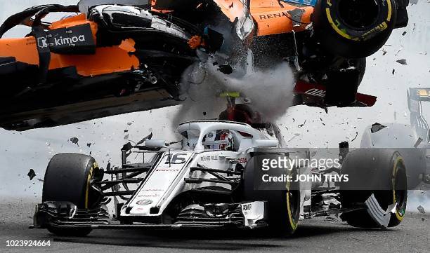 McLaren's Spanish driver Fernando Alonso crashes ontop of Sauber F1's Monegasque driver Charles Leclerc during the first lap of the Belgian Formula...