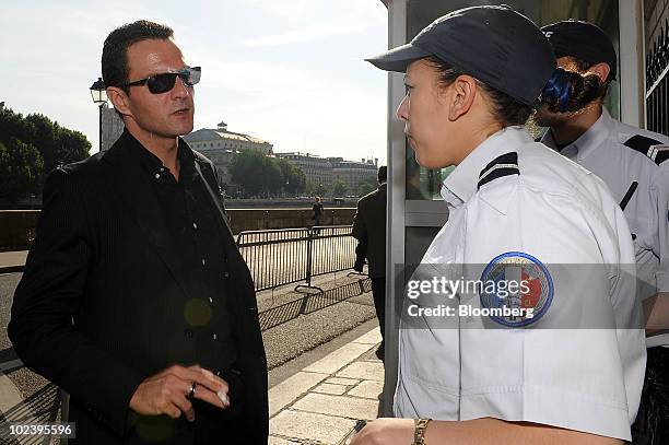 Jerome Kerviel, former Societe Generale SA trader, left, speaks with police officers as he arrives at the courthouse for the final day of his trial...