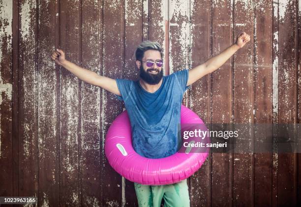 portrait of a young man wearing a float ring - man on float stock pictures, royalty-free photos & images