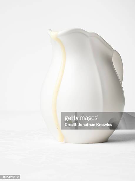 white jug with custard drip - vanillesoße stock-fotos und bilder