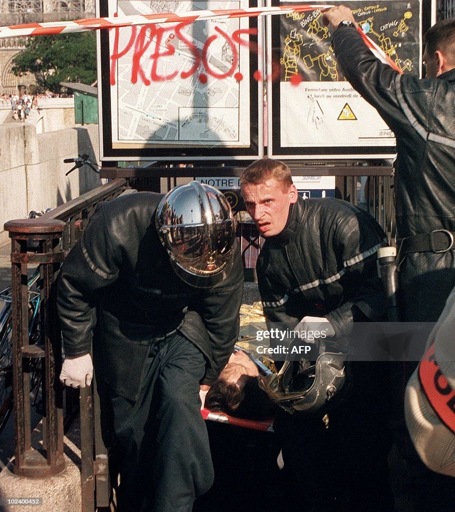 Firemen carry away an injured person aft