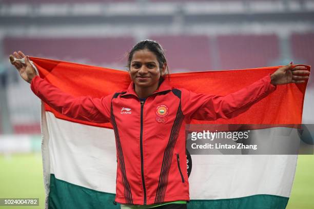 Silver medallist Dutee Chand of India poses on the podium during the awards ceremony for the Athletics Women's 100m final on day eight of the Asian...