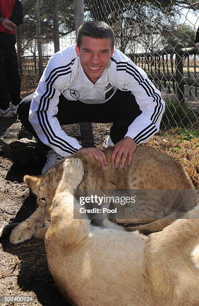 Lukas Podolski of the German National Team strokes lion cups during a visit at the Lion Park on June 25, 2010 in Lanseria, South Africa.