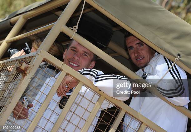 Lukas Podolski and Miroslav Klose of the German national football team take are seen driving with a van during a visit of the Lion Park on June 25,...