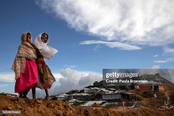 Rohingya girls share a laugh in Kutupalong, the largest refugee camp housing the Rohingya on August 26, 2018 in Kutupalong, Cox's Bazar, Bangladesh....