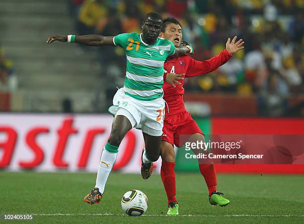 Emmanuel Eboue of Ivory Coast holds off the challenge by Pak Nam-Chol of North Korea during the 2010 FIFA World Cup South Africa Group G match...