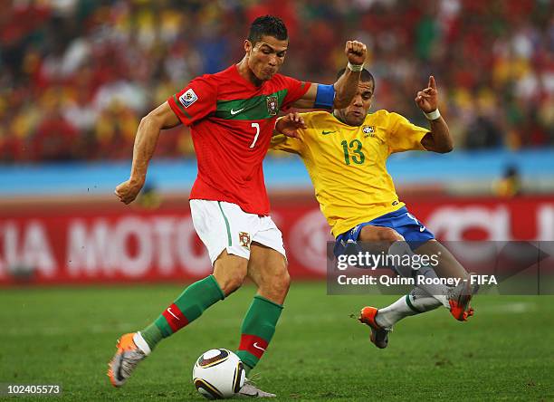 Cristiano Ronaldo of Portugal is challenged by Dani Alves of Brazil during the 2010 FIFA World Cup South Africa Group G match between Portugal and...