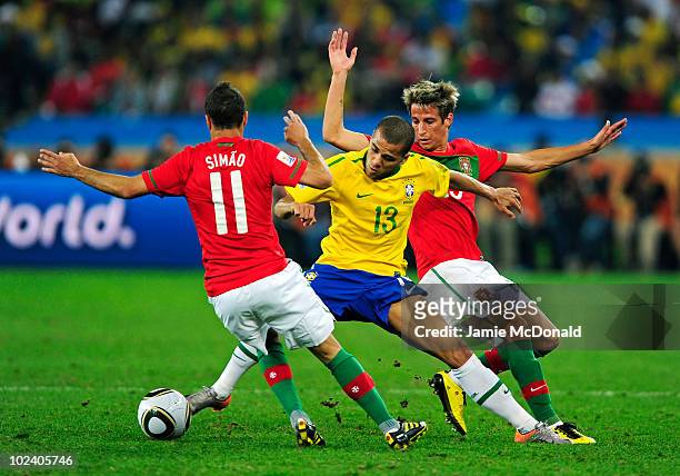 Dani Alves of Brazil is challenged by Simao and Fabio Coentrao of Portugal during the 2010 FIFA World Cup South Africa Group G match between Portugal...