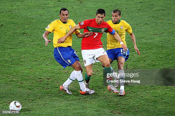 Cristiano Ronaldo of Portugal is closed down by Gilberto Silva and Dani Alves of Brazil during the 2010 FIFA World Cup South Africa Group G match...