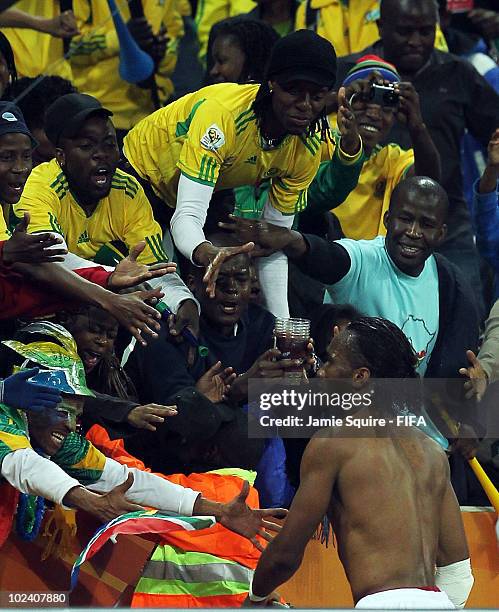 Dejected Didier Drogba of the Ivory Coast throws his boots to fans after victory in the game but elimination from the tournament during the 2010 FIFA...