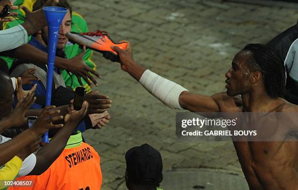 Ivory Coast's striker Didier Drogba gives his shoe to supporters after the Group G first round 2010 World Cup football match Ivory Coast versus North...