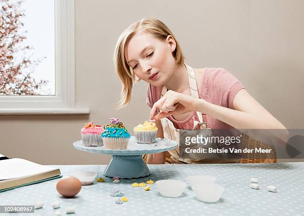 woman decorating cupcakes. - präzision stock-fotos und bilder