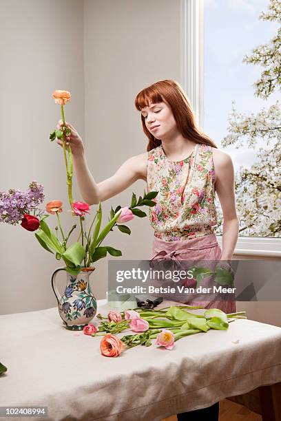 woman arranging flowers. - floral arranging stock pictures, royalty-free photos & images