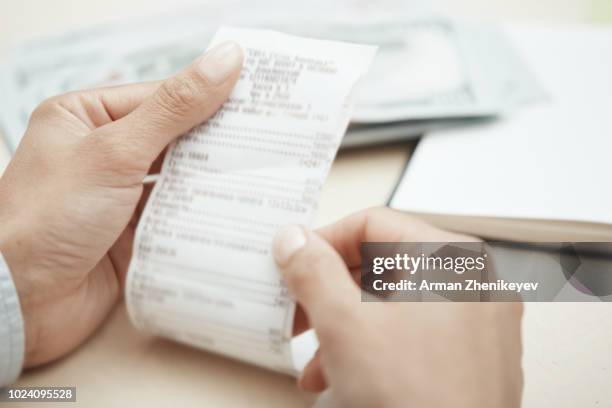 hand of businesswoman checking invoice - cost of shopping stock pictures, royalty-free photos & images