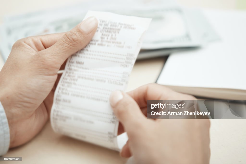 Hand of businesswoman checking invoice