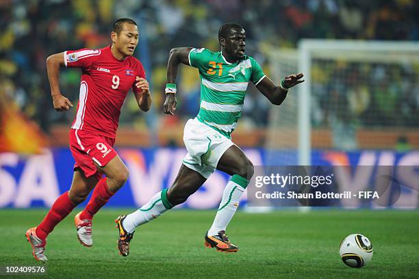 Emmanuel Eboue of Ivory Coast is chased by Jong Tae-Se of North Korea during the 2010 FIFA World Cup South Africa Group G match between North Korea...