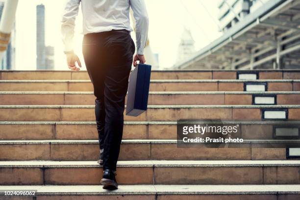 monday morning of work businessman walking up the stairs in a rush hour to work. hurry time. working man - a buisness man with a brifecase stock-fotos und bilder
