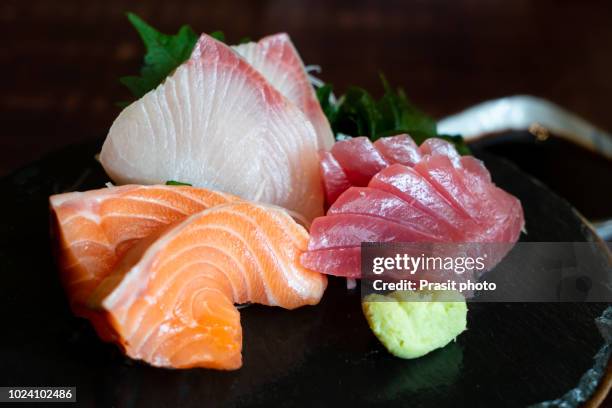 raw fish sashimi traditional japanese food set includes raw salmon, raw tuna, raw yellow tail (hamachi) sliced with sliced radish and vegetable - sashimi imagens e fotografias de stock