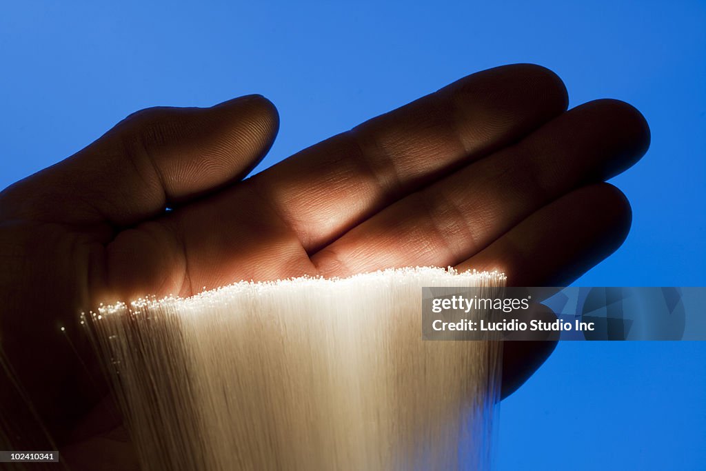 Mans hand illuminated with fiber optic strands