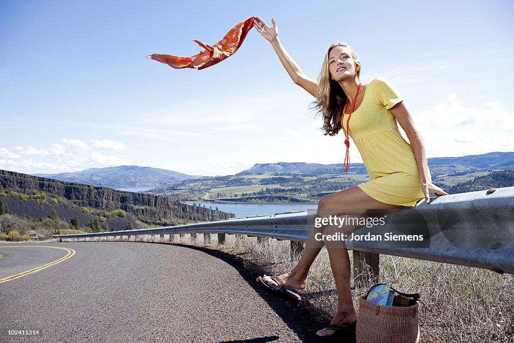 A beautiful woman hitch hiking on the side