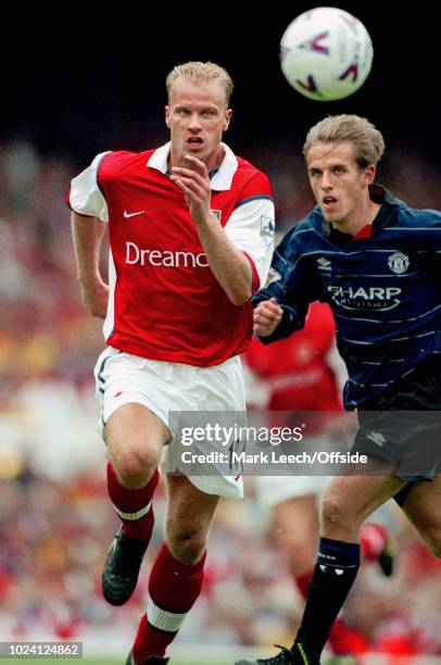 August 1999 - Premiership Football - Arsenal v Manchester United - Dennis Bergkamp of Arsenal and Phil Neville of Manchester United race for the ball...