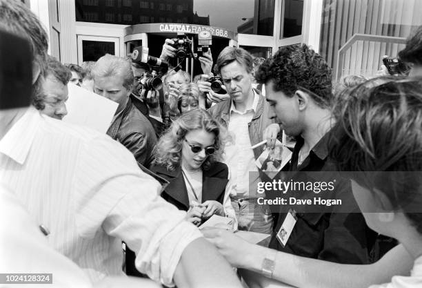 Australian pop singer and star of TV's 'Neighbours' Kylie Minogue signs autographs at Capital Radio's London studios, 7th July 1989.