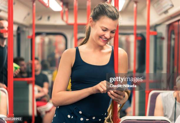 woman traveling by subway and using phone - prague train stock pictures, royalty-free photos & images