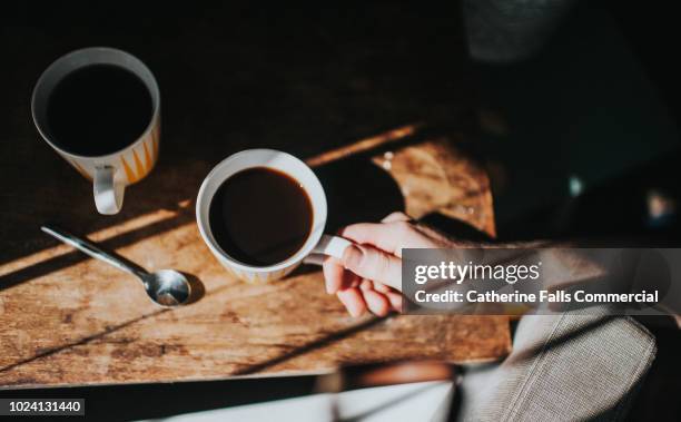 hand holding a coffee cup - coffee spoon stock pictures, royalty-free photos & images