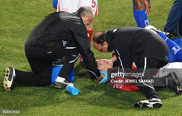 Switzerland's defender Stephane Grichting is treated by medics after clashing with Honduras' midfielder Jerry Palacios during the Group H first round...