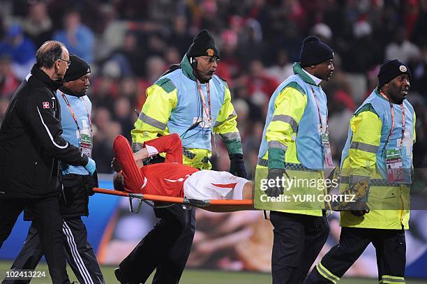 Switzerland's defender Stephane Grichting leaves the pitch on a stretcher after a clash with Honduras' midfielder Jerry Palacios during the Group H...