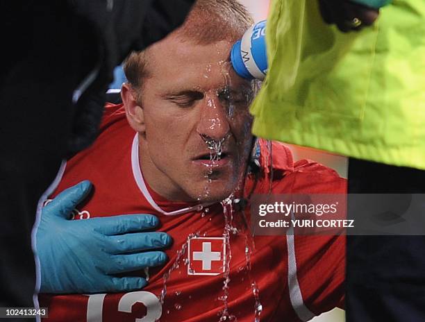 Switzerland's defender Stephane Grichting is treated by medics after clashing with Honduras' midfielder Jerry Palacios during the Group H first round...