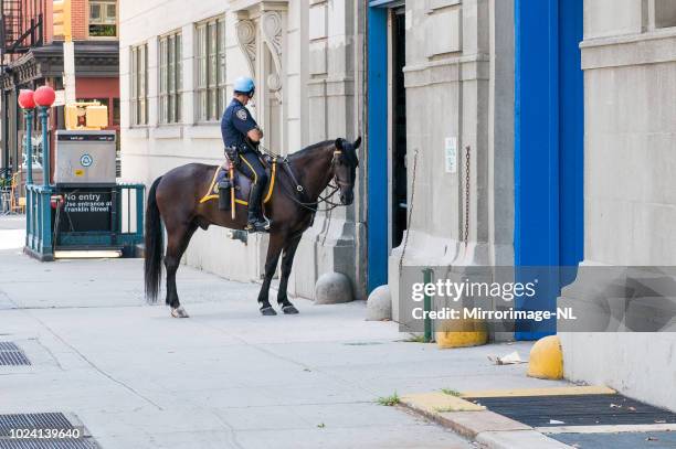 mounted police officer bij stallen van 1ste precinct in manhattan - bereden politie stockfoto's en -beelden