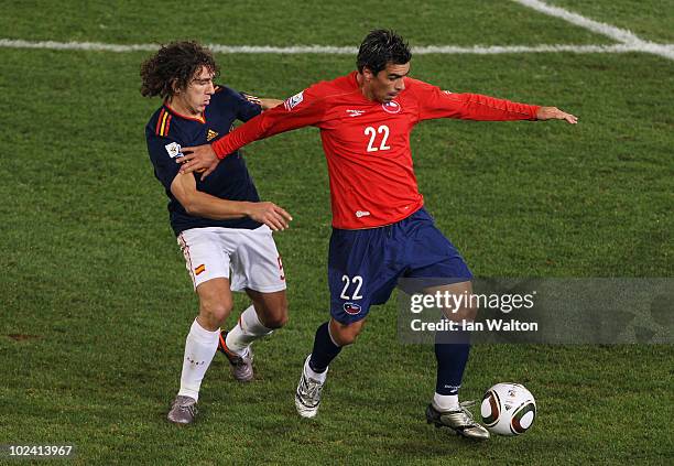 Esteban Paredes of Chile fends off the challenge of Carles Puyol of Spain during the 2010 FIFA World Cup South Africa Group H match between Chile and...