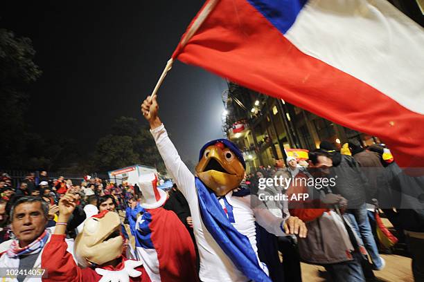 Supporter of Chile wearing a costume of Chilean comic hero Condorito waves a Chilean flag as he arrives outside Loftus Verfeld stadium in...