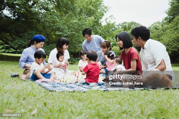 multi family enjoying picnic in the park - large group in park imagens e fotografias de stock