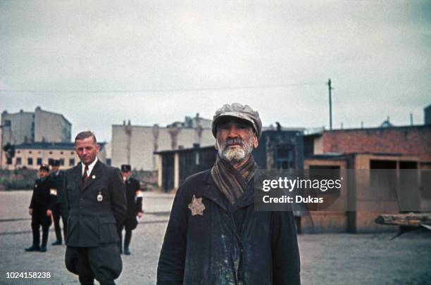 Jewish man wearing a Star of David badge is watched by Hans Biebow, chief of the German Nazi administration of the Łódź Ghetto in Łódź, occupied...