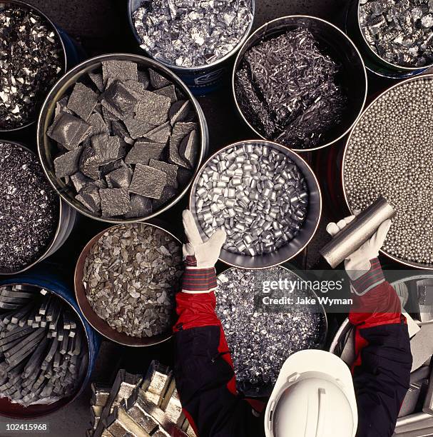 worker sorting metals in a foundry - métallurgie et sidérurgie photos et images de collection