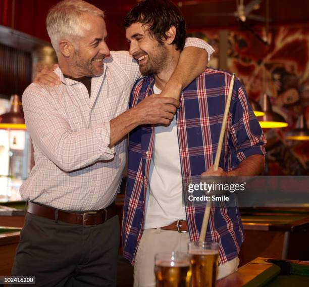 father and son hugging each other, laughing - friends smile stock-fotos und bilder