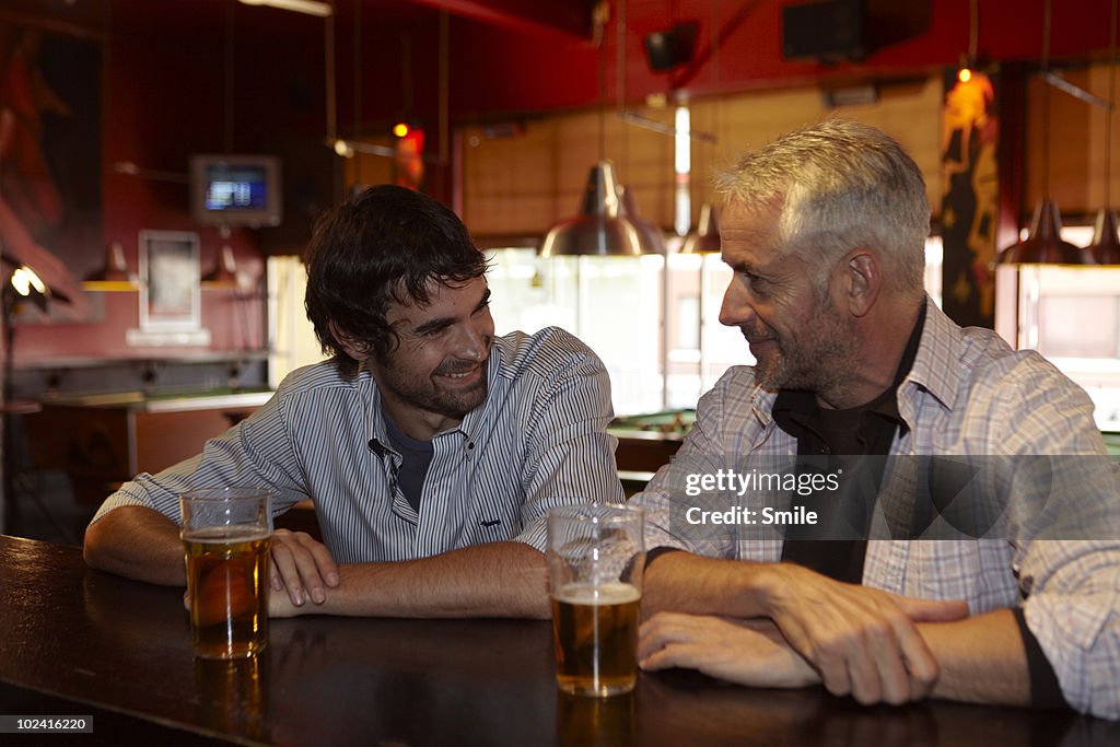 Father and son chatting in bar