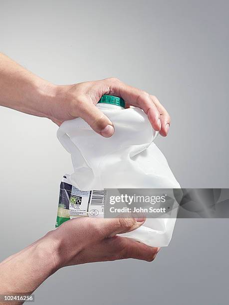 man holding a milk carton for recycling - crush fotografías e imágenes de stock