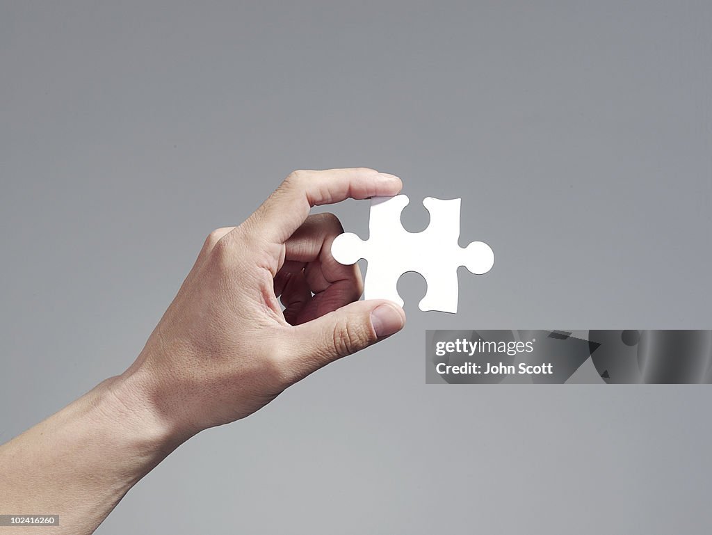Man holding a jigsaw puzzle piece