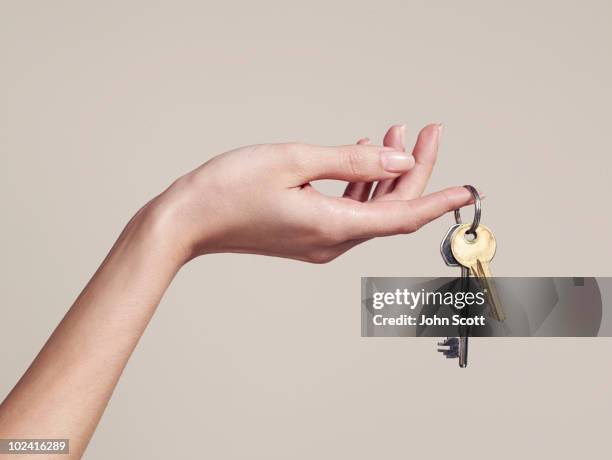 woman holding keys - llavero fotografías e imágenes de stock