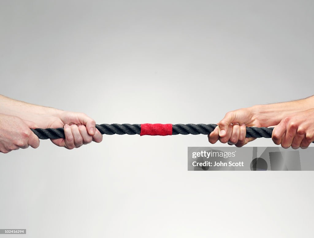 Hands pulling on rope during game of tug-of-war