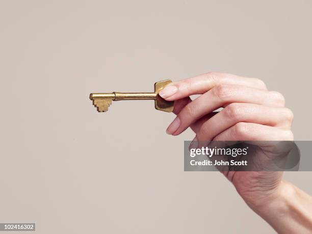 woman holding a key, close-up of hand - house key hands stock pictures, royalty-free photos & images