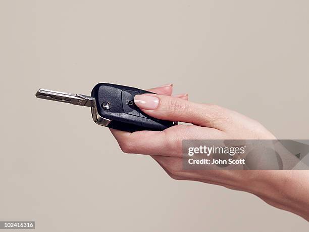 woman holding a car key, close-up of hand - car keys hand stockfoto's en -beelden