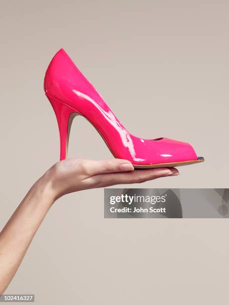 woman holding a high heel shoe - zapatos mujer fotografías e imágenes de stock